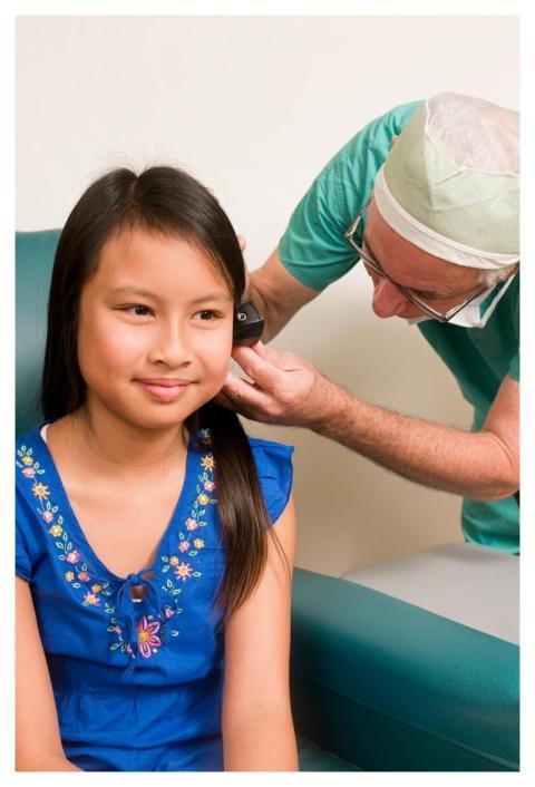 A clinician conducting an examination of a young f