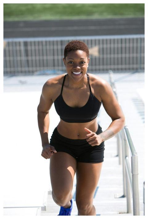 Fit woman with short hair jogging outdoors, showin