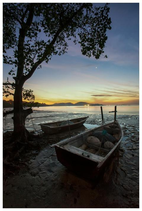 A serene scene of wooden boats at the shore during