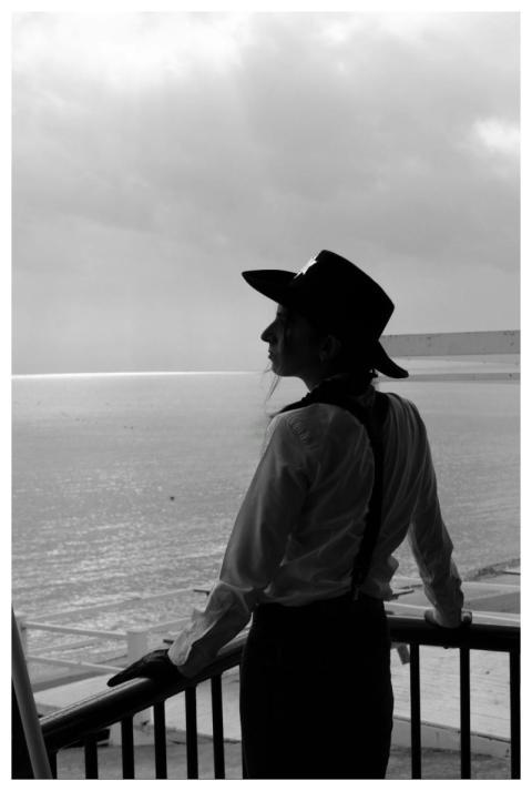 Black and white silhouette of a person in a hat ga