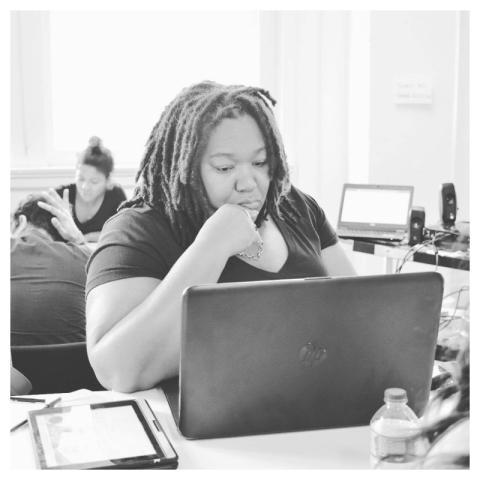 Woman deeply focused on her laptop in a modern off