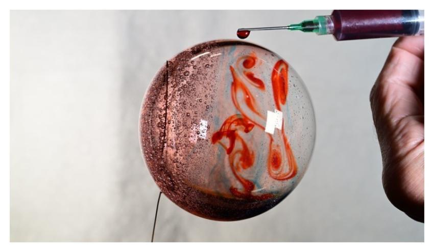 Sphere of water filled with food coloring in micro