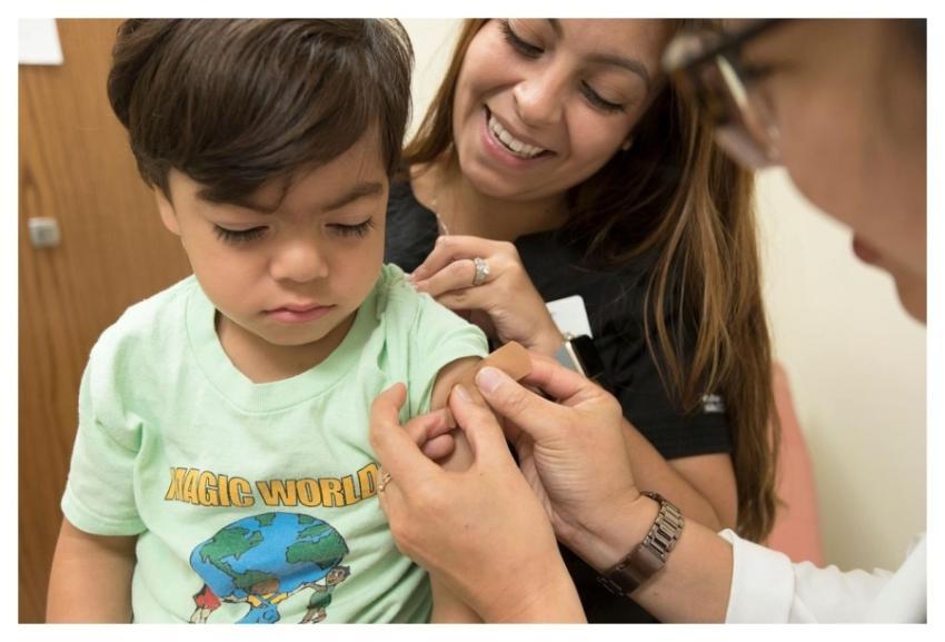 A doctor placing a bandage on the injection site o