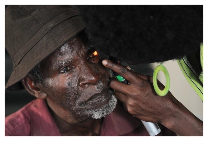 community health worker examines patient’s