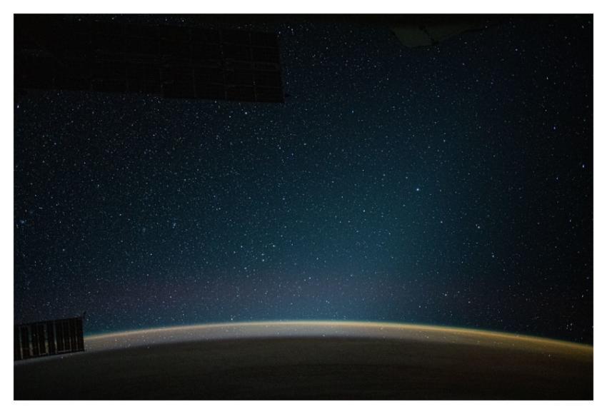 An atmospheric glow blankets Earth beneath a starr