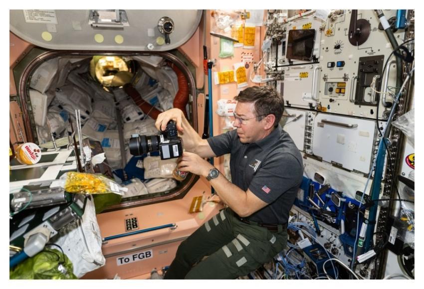 Astronaut Mike Barratt photographs food packs in t