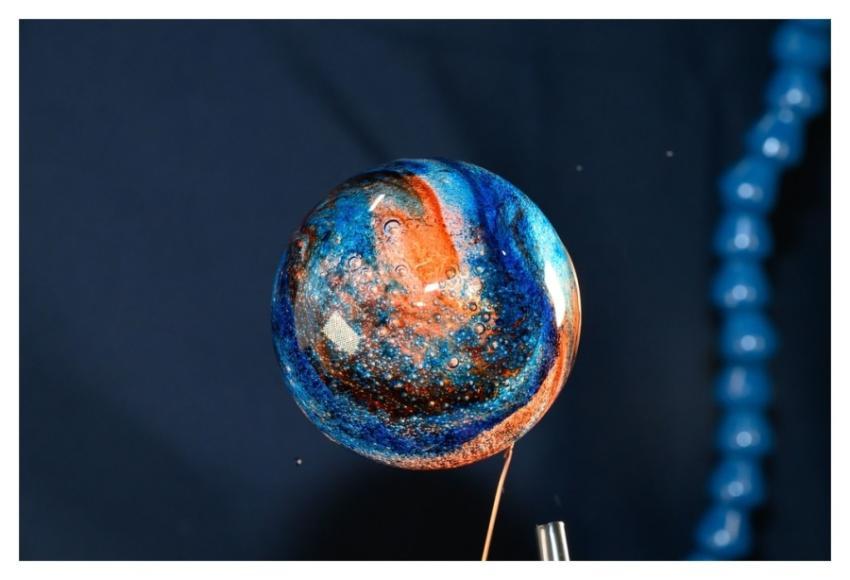 Sphere of water filled with food coloring in micro