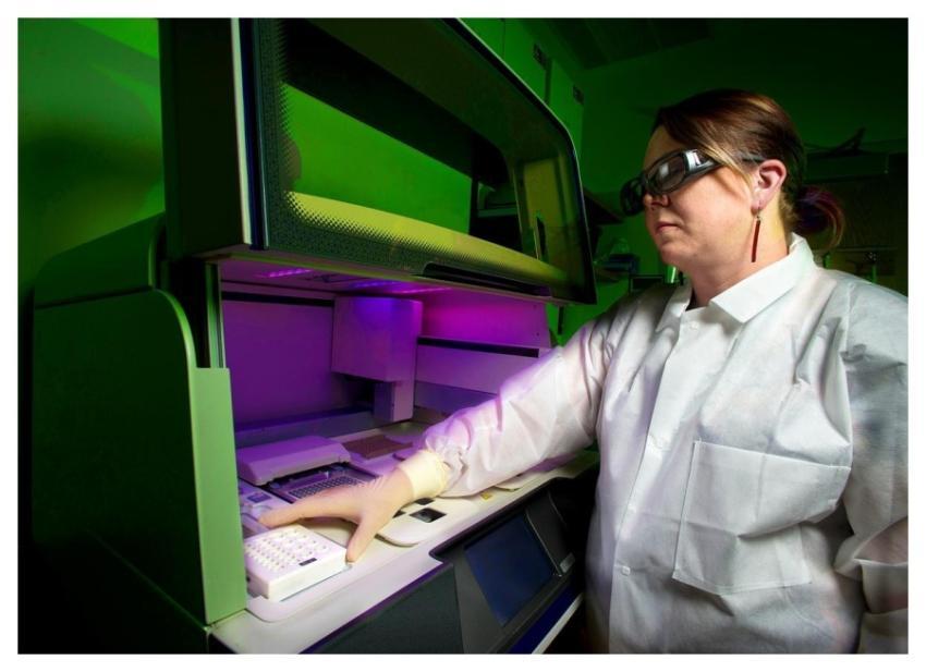 A scientist using a whole genome DNA sequencer, in