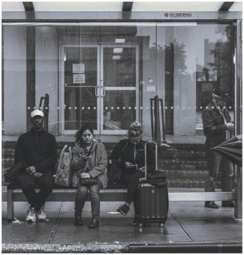People waiting at a New York bus stop, showcasing