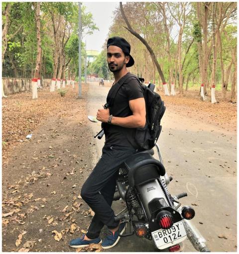 A man enjoys leisure time posing with a motorcycle