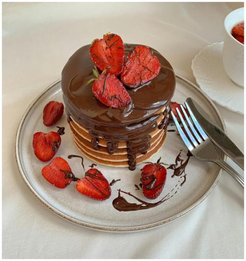 A tempting stack of pancakes topped with chocolate
