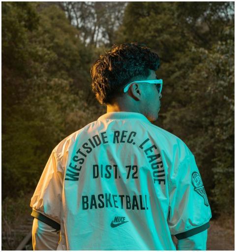 Person in sunglasses and jacket outdoors, vibrant