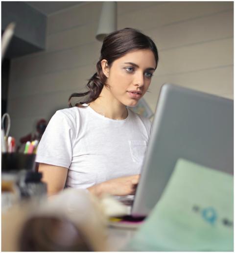 Young woman attentively working on her laptop in a