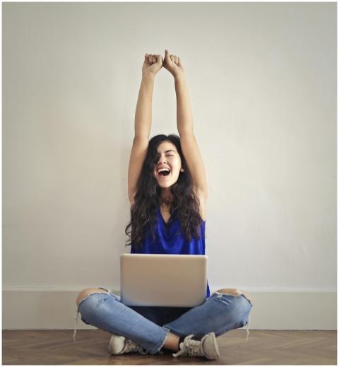 Happy woman with laptop, celebrating success indoo