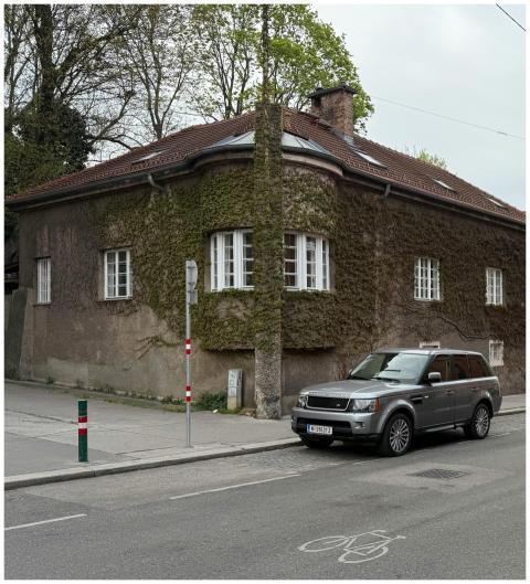 A picturesque ivy-covered house with a parked SUV