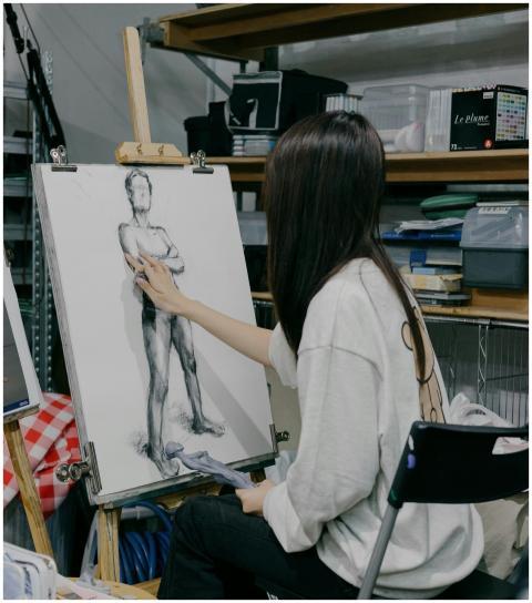 Artist sketching a figure in a Tokyo studio, showc
