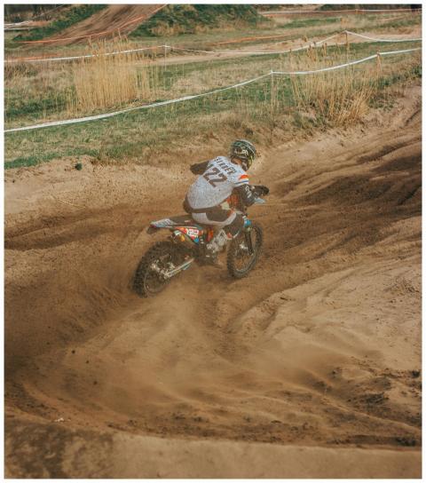 Rider navigating a challenging dirt track during a