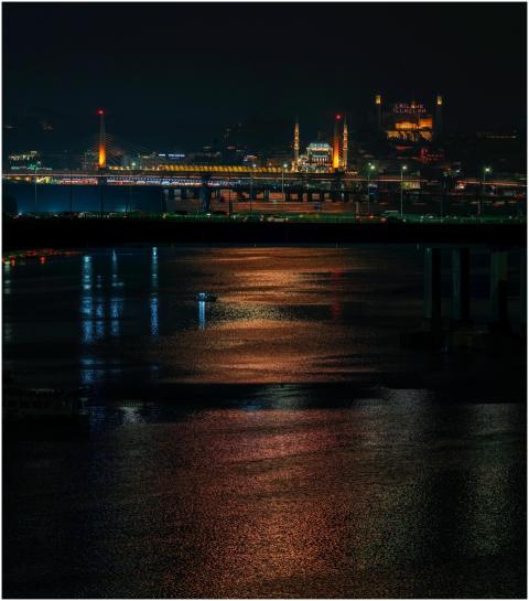 Stunning night view of a lit-up bridge with city l