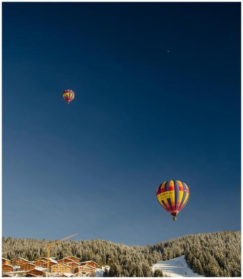 Colorful hot air balloons soaring above a snowy fo