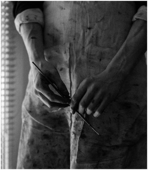Black and white close-up of artist's hands holding