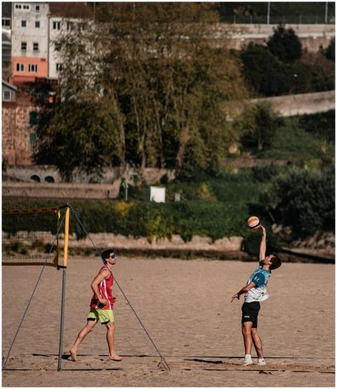 Two young men enjoy a game of beach volleyball on
