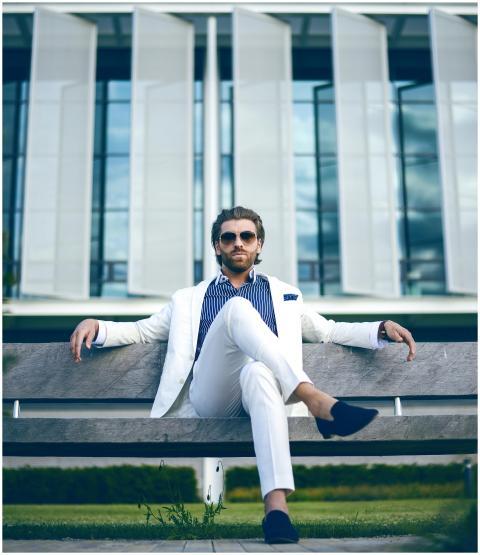 Fashionable man in white suit sitting confidently