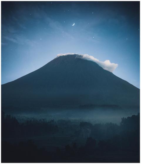 Mystical mountain peak bathed in moonlight, surrou
