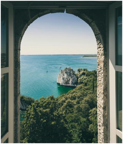 Idyllic view of Duino Cliffs and sea through arche