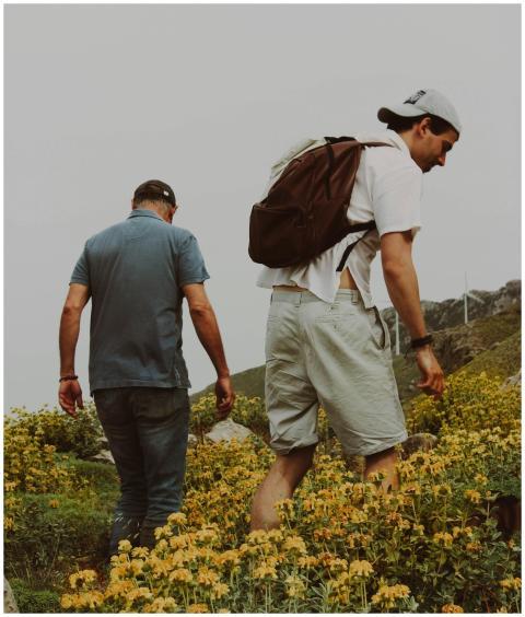 Two men hiking through a vibrant field of flowers