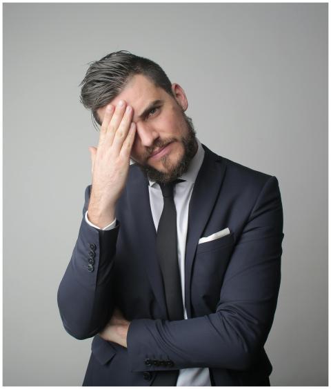 A portrait of a stressed businessman in a dark sui