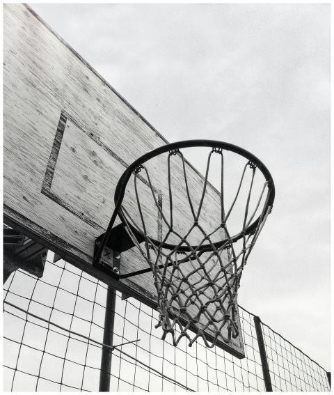Monochrome shot of a basketball hoop against the s