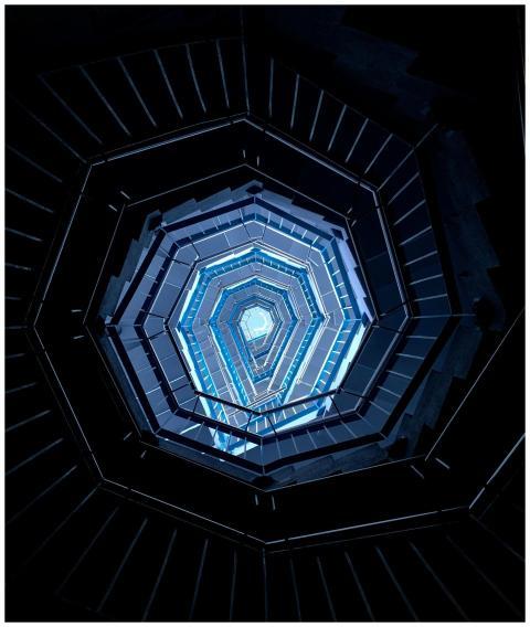 Upward view of a spiral staircase showing a hexago