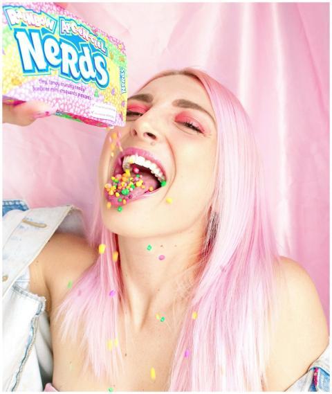 Young woman with pink hair playfully enjoying rain