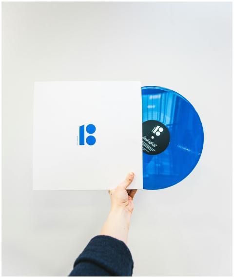 A hand holding a blue vinyl record partially out o