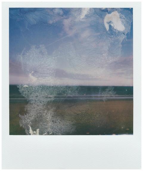 A vintage Polaroid image of a seaside landscape wi