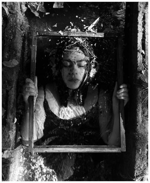 Black and white image of a woman holding a frame,