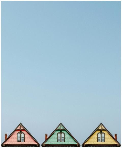 Three colorful triangular rooftops against a clear