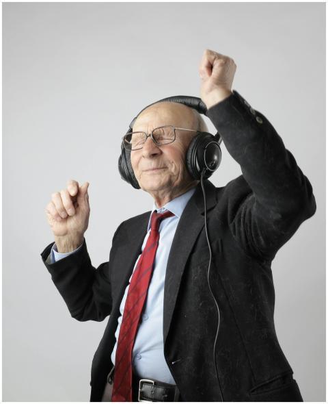 Senior man enjoying music with headphones, express