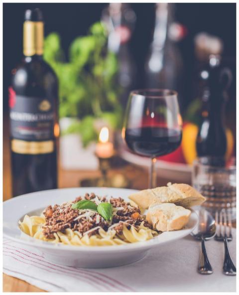 Delicious pasta meal with red wine, served in a wa