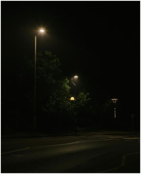 A quiet urban street at night illuminated by stree
