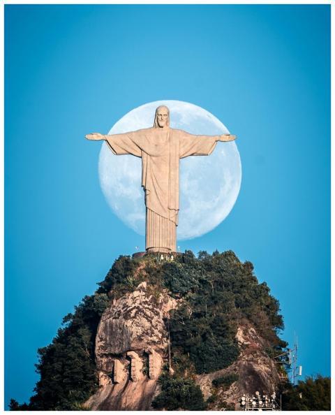 Iconic Christ the Redeemer statue with full moon b