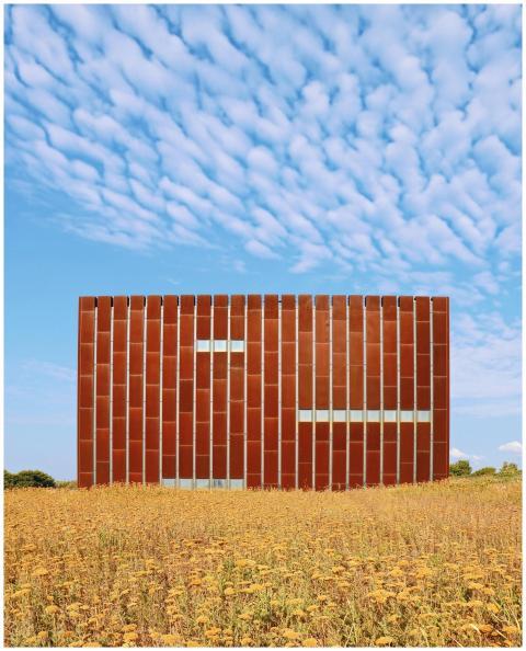 Contemporary building in a field with a summer sky
