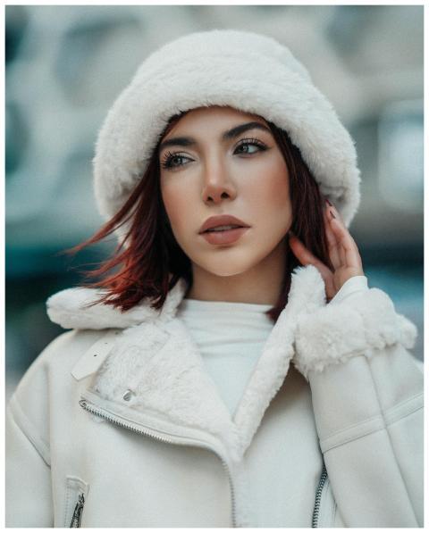 Elegant woman in winter attire posing outdoors in