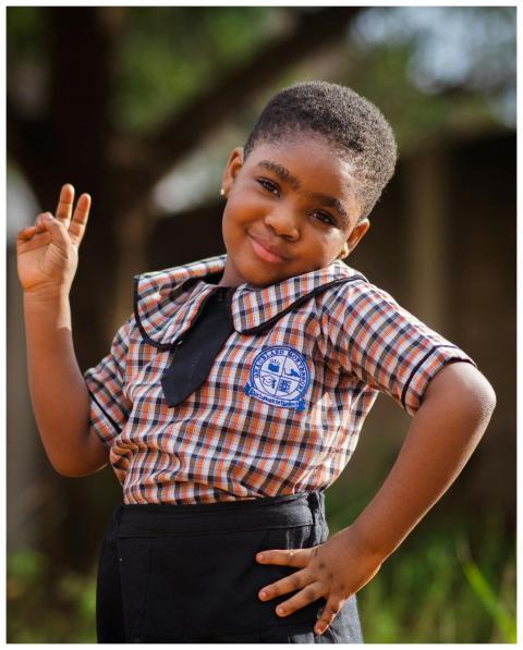 Charming young girl in school uniform confidently
