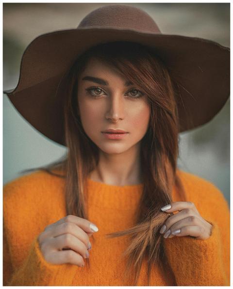 Elegant portrait of a woman in a hat and sweater o