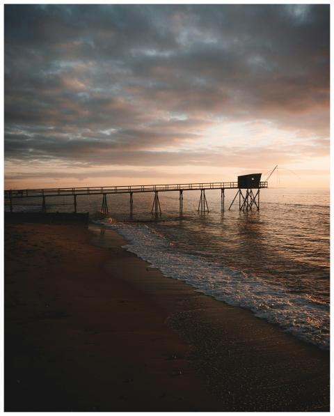 A tranquil seaside view of a pier extending into t