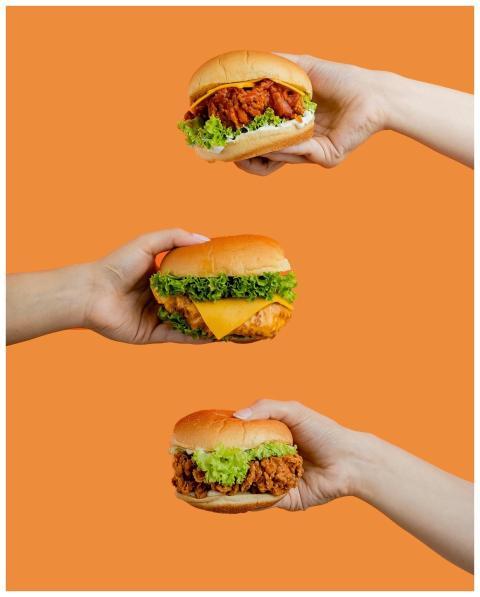 Three chicken burgers with lettuce and cheese, hel