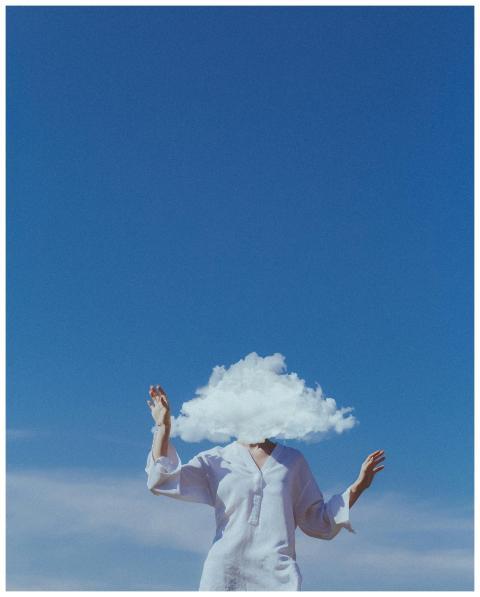 A surreal image of a woman with a cloud covering h