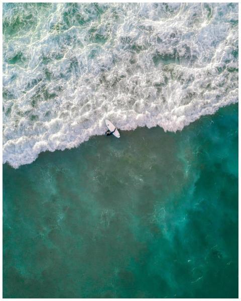 Captivating aerial shot of a surfer riding waves a