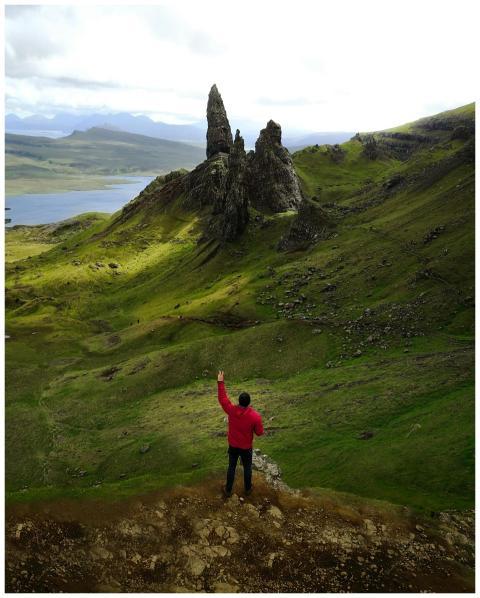 A lone hiker in a red jacket stands before the ico